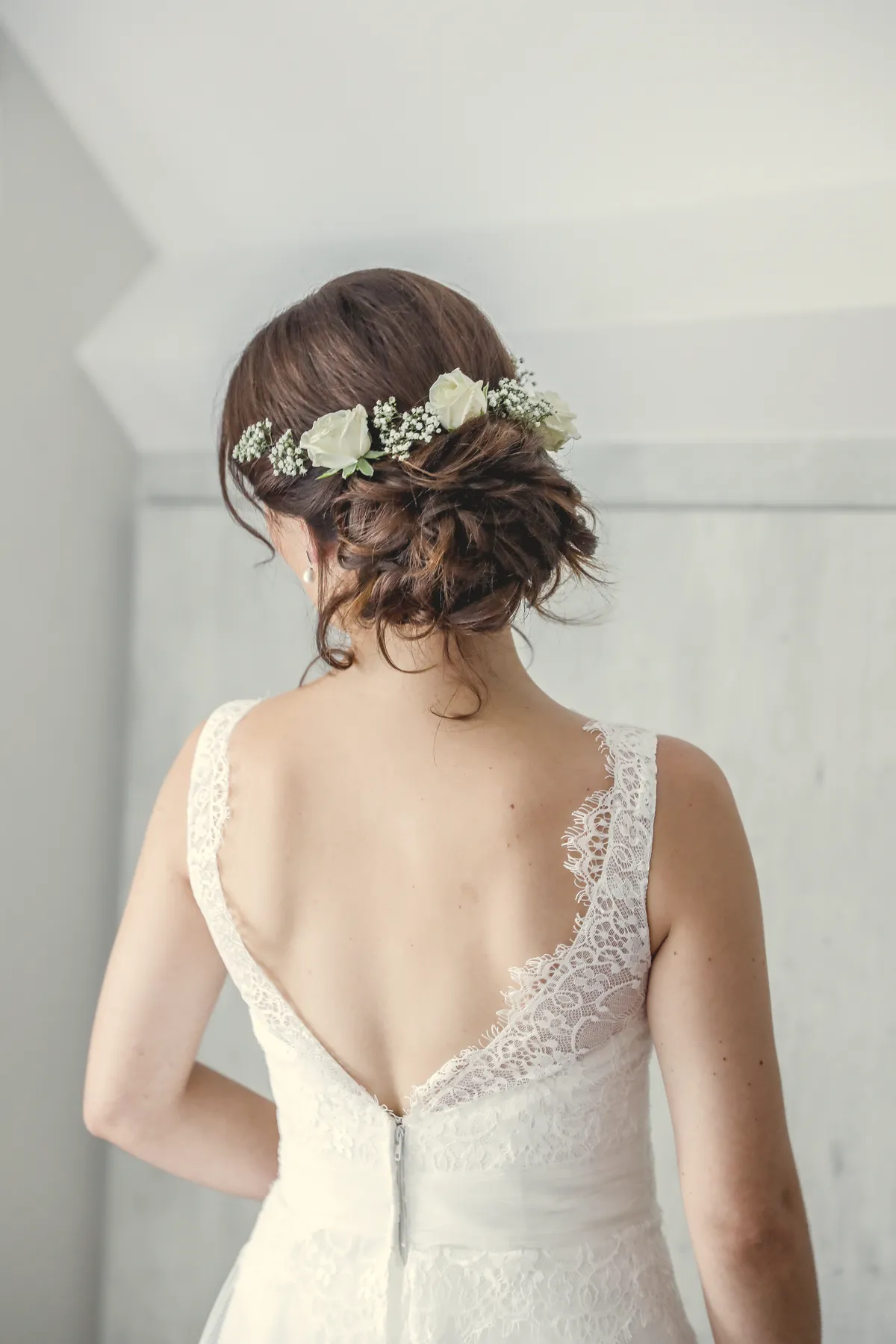 Le dos de la mariée, une couronne de fleurs dans les cheveux.