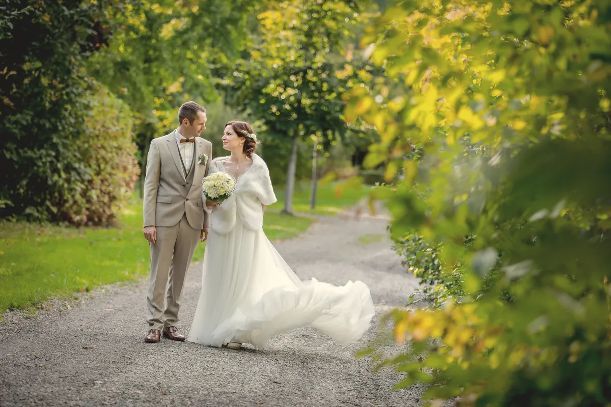 Les mariés sur un chemin, sous les feuillages d’automne.