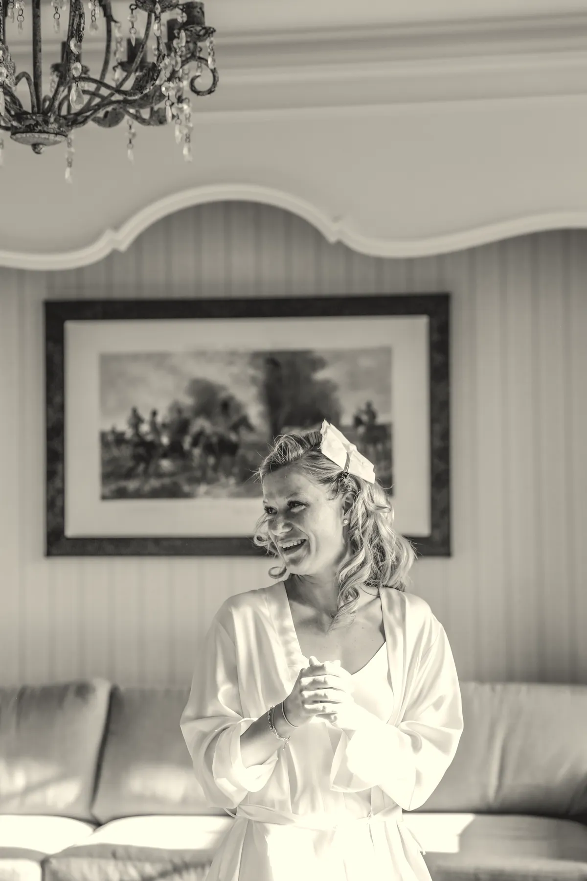 En noir et blanc, la mariée rit dans le salon du château.