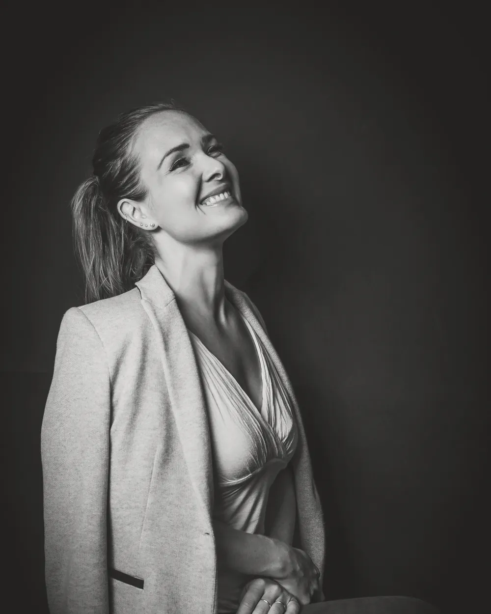 Portrait de Charlotte Doulière en noir et blanc, souriante, le regard vers la lumière.