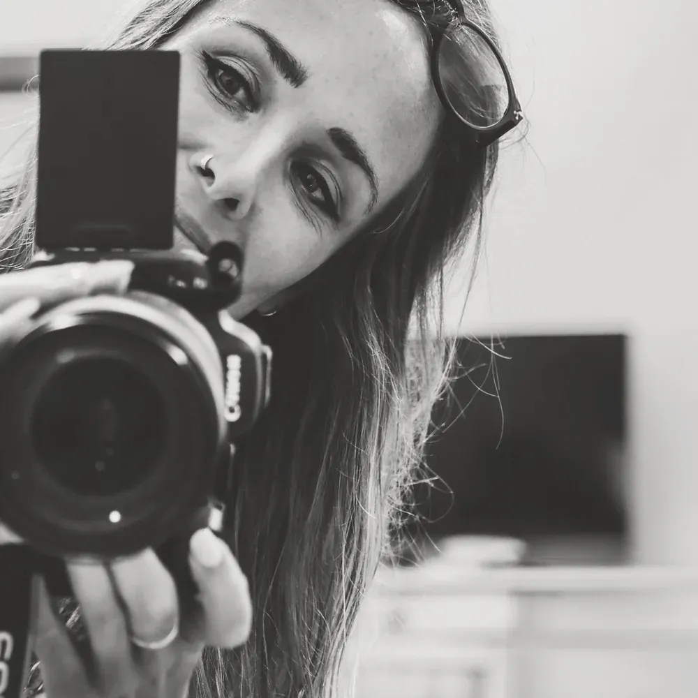 Charlotte Doulière, son appareil photo devant le visage.